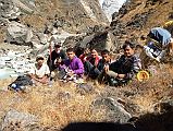 302 Crew Taking A Rest On The Way To Annapurna North Base Camp - Dhansing, Jerome Ryan, Ram Bahadar Tamang, Ang Phuri Sherpa, Dhan Bahadur Tamang, Gyan Tamang We hugged the Miristi Khola, bushwhacking our way thru low thorny bushes, clumps of grass, and big rocks. Up and down, crossing small side streams - the toughest hiking I have ever done! We paused briefly for a team photo: porter Dhansing, Jerome Ryan, porter Ram Bahadar Tamang, cook Ang Phuri Sherpa, porter Dhan Bahadur Tamang, and guide Gyan Tamang.